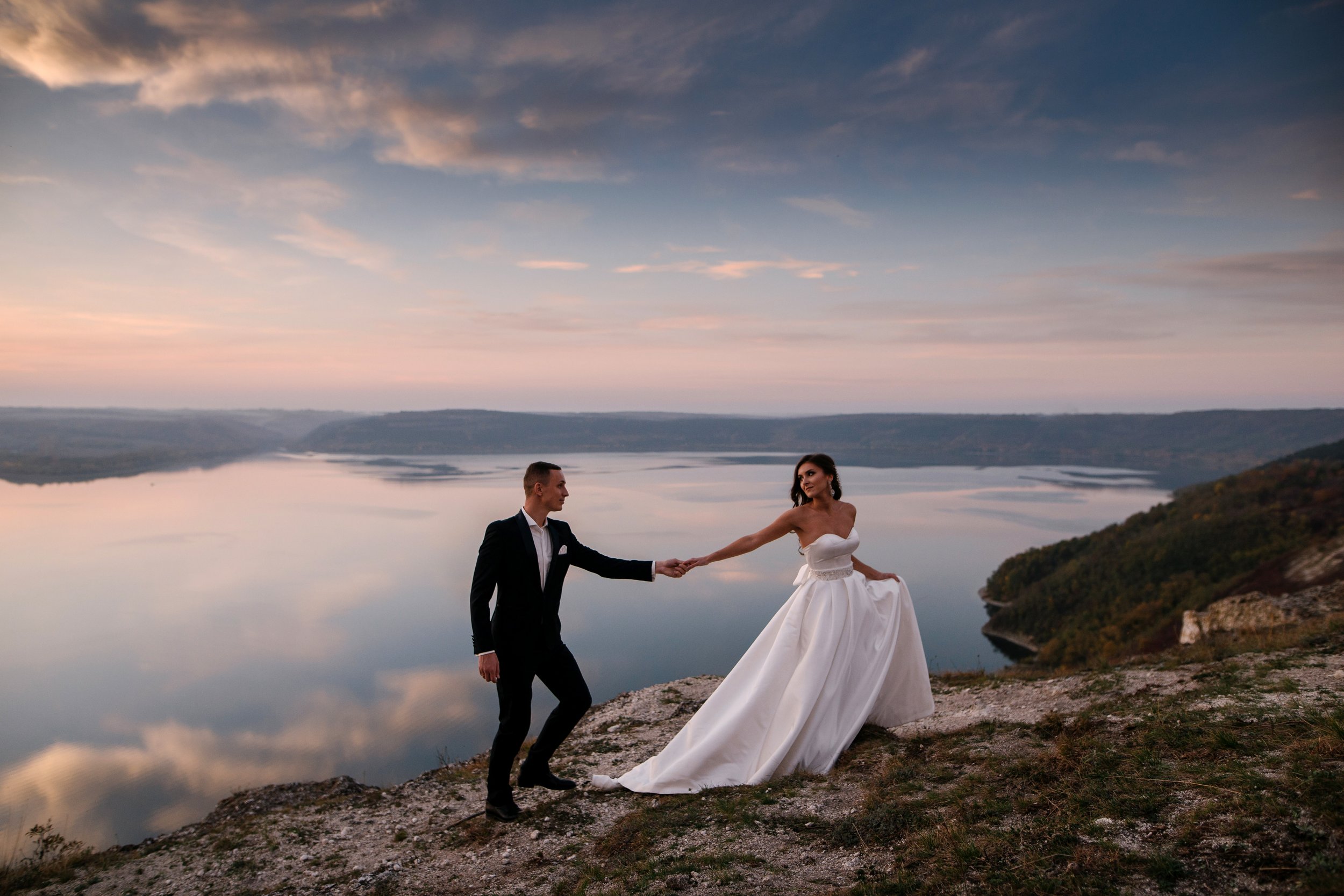Sensual wedding couple groom and bride in a long white dress sta